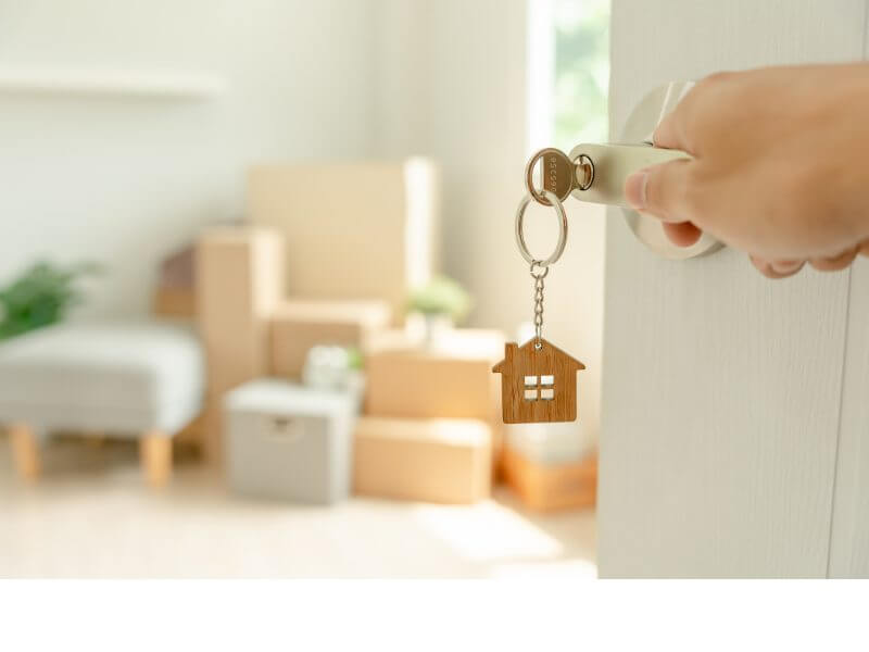 Handing over keys in a home filled with moving boxes